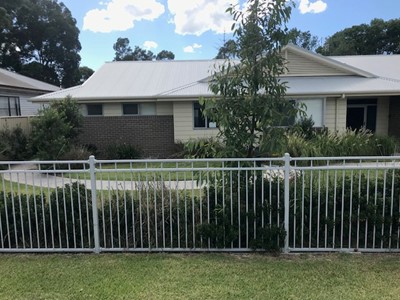 Self-contained unit in Lifestyle Solutions Specialist Disability Accommodation in Argenton, Newcastle, NSW, showing fencing and an accessible pathway running the length of the unit 