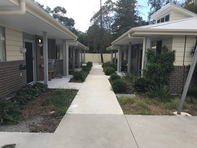 Accessible pathway to communal outdoor area between self-contained units  in Lifestyle Solutions Specialist Disability Accommodation in Argenton, Newcastle, NSW