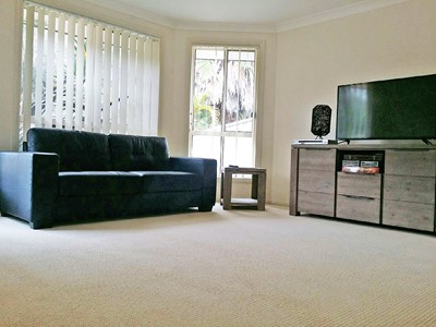 Lounge with television in  Lifestyle Solutions four-bedroom Supported Independent Living (SIL) house at Forster, NSW