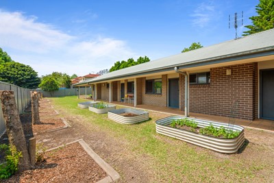 Communal garden plots for planting vegetables or flowers and entrance to apartments  at Lifestyle Solutions Supported Independent Living property in Wyong, NSW
