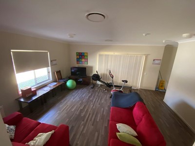 Living area with mini-gym in Lifestyle Solutions four-bedroom Supported Independent Living (SIL) house in Silkstone, Qld