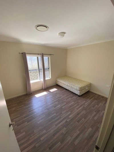 Airy bedroom with large window in Lifestyle Solutions four-bedroom Supported Independent Living (SIL) house in Silkstone, Qld