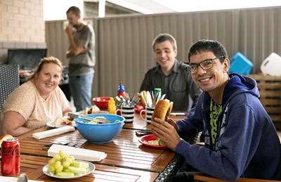 Residents enjoying a barbecue in shared outdoor area in Lifestyle Solutions Supported Independent Living property in Albion Park Rail, NSW