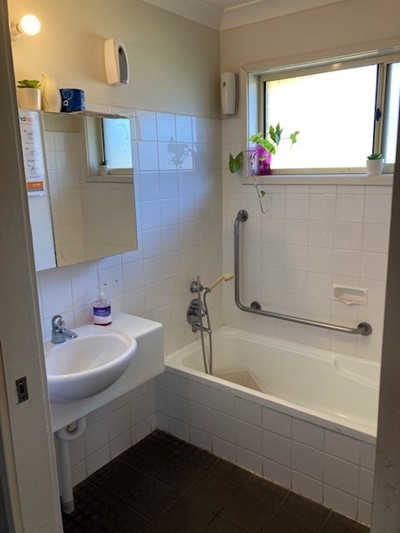 Bathroom showing bath and sink in Lifestyle Solutions two-bedroom Supported Independent Living accommodation in Warabrook, NSW