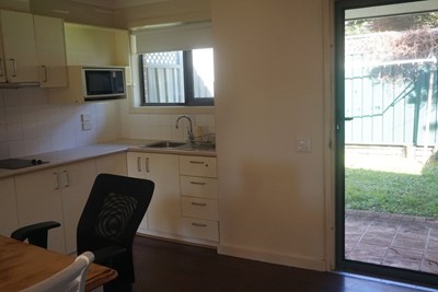 Kitchen, dining area and access to private courtyard in self-contained apartment  at Lifestyle Solutions Supported Independent Living property in Wyong, NSW