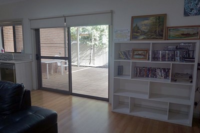 Communal lounge with view of outdoor area in Lifestyle Solutions Supported Independent Living property with two self-contained villas in Fairfield, Sydney