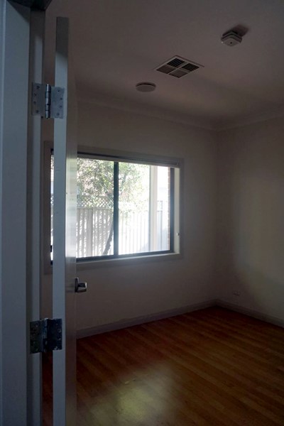 Villa bedroom with window with leafy view in Lifestyle Solutions Supported Independent Living property with two self-contained villas in Fairfield, Sydney