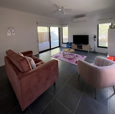 Lounge showing soft furnishings and TV in Lifestyle Solutions Supported Independent Living accommodation in Pallara, Qld